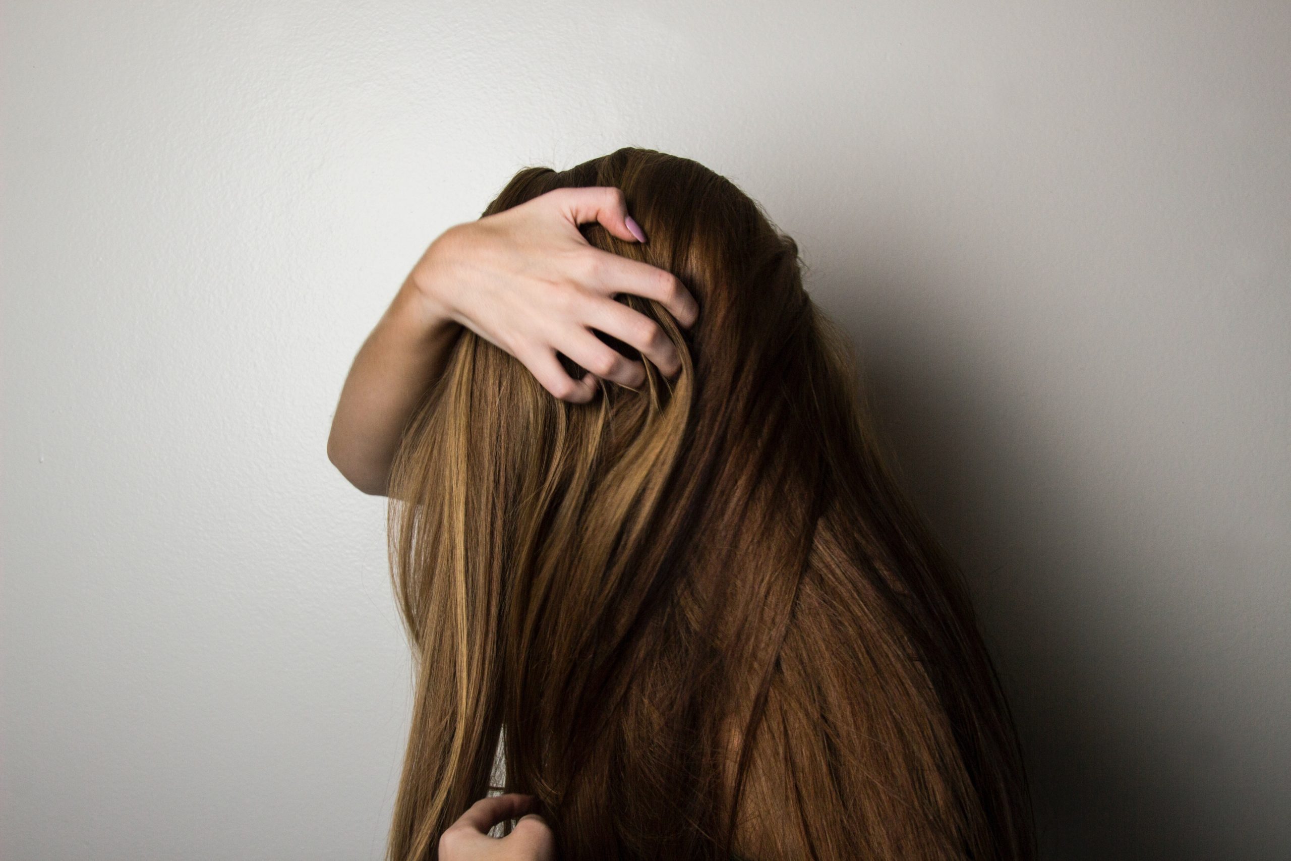 A woman hides her face with her hair.